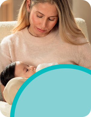 [Translate to French (Reborn):] Mother with baby and baby bottle